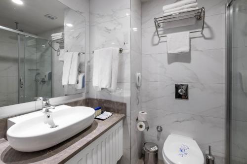 un bagno bianco con lavandino e WC di Long Beach Alanya - Ultra All Inclusive ad Avsallar