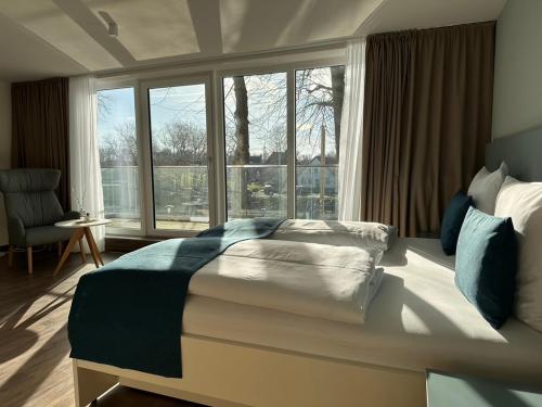 a bedroom with a bed and a large window at Hotel Schöne Aussicht in Wilhelmshaven