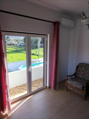a room with a sliding glass door and a chair at Casa O Limoeiro - Charming Village Apartment in Ponte de Lima