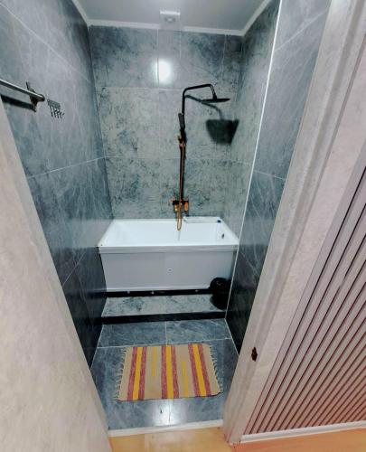 un bagno con vasca da bagno in una stanza di ZhanHotels a Almaty