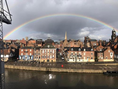 a rainbow over a city with buildings and water at The Lowther Hotel in York