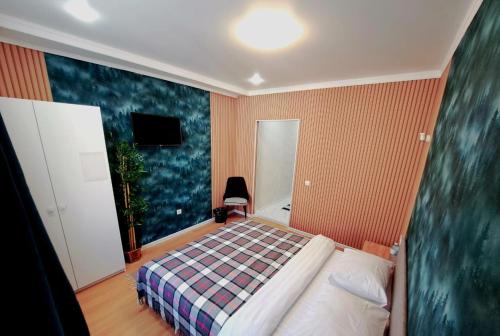 a bedroom with a bed with a checkered blanket at ZhanHotels in Almaty