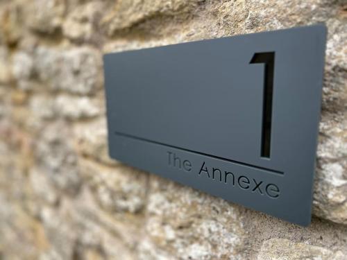 a clock on the side of a stone wall at The Annexe in Bruton