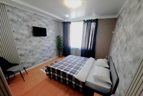 a small bedroom with a bed and a window at ZhanHotels in Almaty