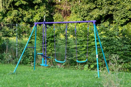 a playground with two swings in the grass at Apartmány Resort Vrchlabí in Vrchlabí