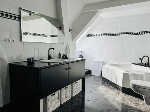 a bathroom with a sink and a toilet and a tub at Schlosskoje - Ihr FerienZuhause in der Pfalz in Neustadt an der Weinstraße