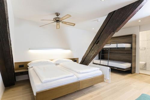 a bedroom with two beds and a ceiling fan at ROESLI Guest House in Luzern