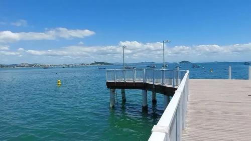 a pier in the middle of the water with boats at Apartamento Encantador Penha Beto Carrero World in Penha