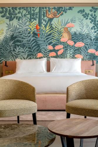 a hotel room with a bed and two chairs at Casa Faraona Luxury Residences in Madrid