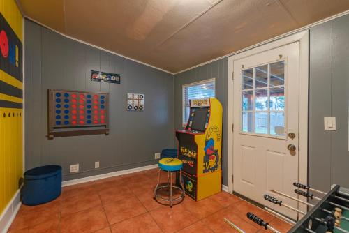 a room with a pinball machine next to a door at Texas Vacation Home, Game Room & Pool By Sixflags in San Antonio