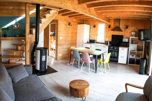 ein Wohnzimmer und eine Küche mit einem Tisch und Stühlen in der Unterkunft Le petit Repaire de Sailhan, Ecolodges in Sailhan