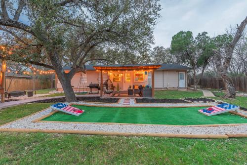 a backyard with a house with a green lawn at Texas Vacation Home, Game Room & Pool By Sixflags in San Antonio