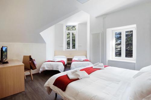3 camas en una habitación con paredes y ventanas blancas en Hotel Croda Rossa, en Carbonin
