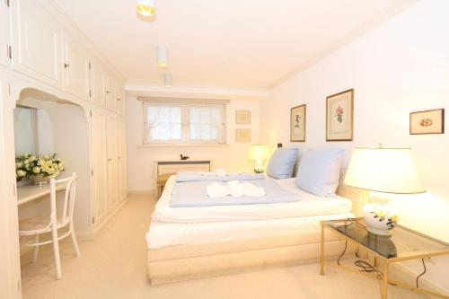 Biała sypialnia z dużym łóżkiem i biurkiem w obiekcie Barteaux Kampenkliff w mieście Kampen