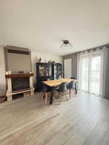 uma sala de jantar com uma mesa e cadeiras e uma lareira em Maison aux Portes de Paris em Vitry-sur-Seine