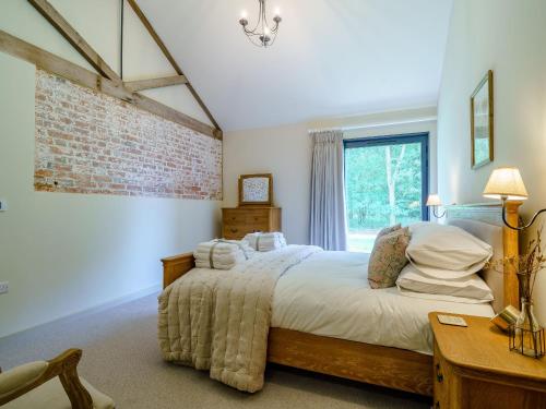 a bedroom with a bed and a brick wall at 2 Pheasant in East Ilsley