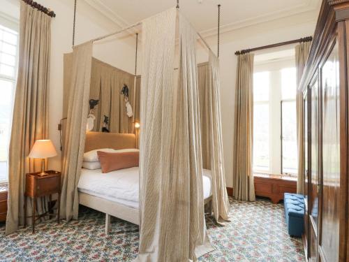 a bedroom with a canopy bed with curtains at Derry - Mar Lodge Estate in Ballater