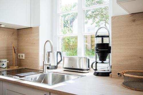 a kitchen with a sink and a coffee maker at Haus Wattpieper in Munkmarsch