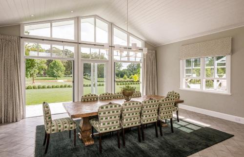 a dining room with a wooden table and chairs at Isca House, Exeter, NSW in Exeter