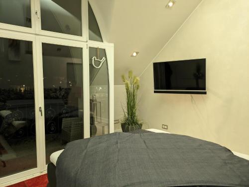 Schlafzimmer mit einem Bett und einem Flachbild-TV in der Unterkunft Stefans Stadthaus in Saarburg