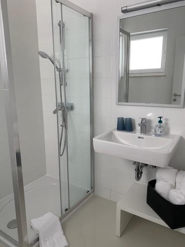 Un baño con ducha, lavabo y espejo. en Villa Franka, en Brela