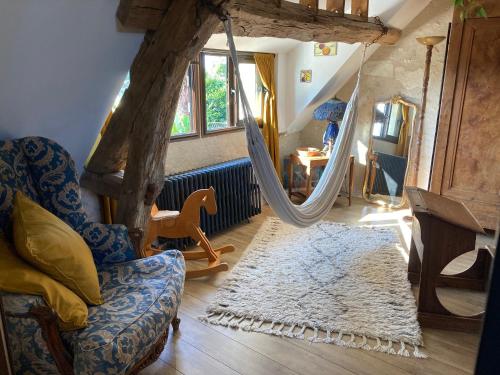 a living room with a chair and a hammock at Chambre d'Hôtes chez Gustave & Compagnie in Choussy
