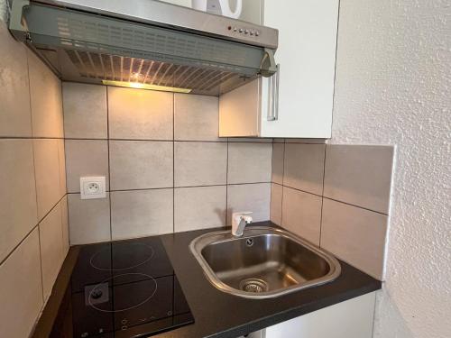 uma pequena cozinha com um lavatório e um micro-ondas em Studio Saint-Cyprien, 1 pièce, 2 personnes - FR-1-753-20 em Saint-Cyprien