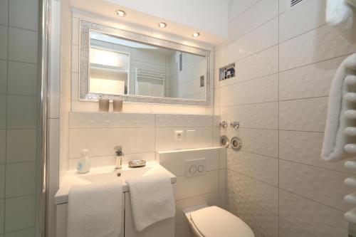 uma casa de banho com um lavatório, um WC e um espelho. em Haus am Meer14 - App 129WB em Westerland