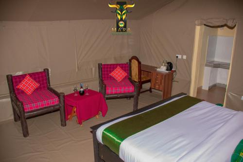 1 dormitorio con 1 cama, 2 sillas y mesa en Mara Olodare, en Ololaimutiek