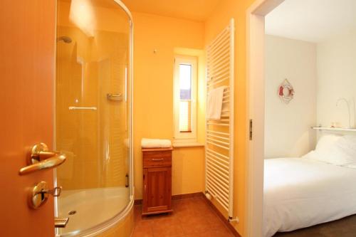 ein Bad mit einer Dusche, einem Bett und einer Badewanne in der Unterkunft Möwennest in Westerland