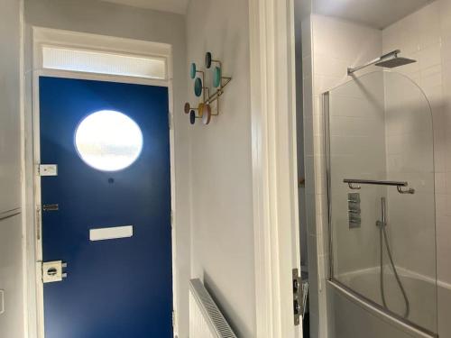 a bathroom with a blue door and a shower at Bright flat in Stoke Newington in London