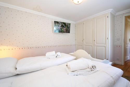 un dormitorio blanco con 2 camas blancas. en Krauthahn Anbau, en Westerland