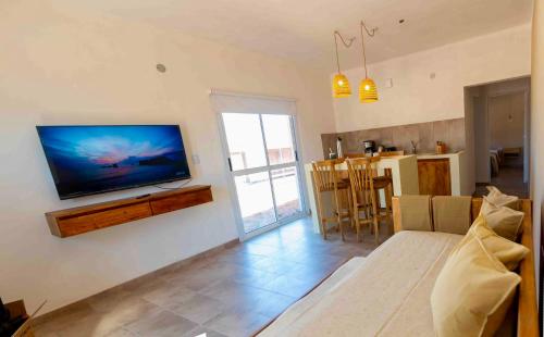 a living room with a flat screen tv on a wall at Cabañas Los Viñadores in Villa Unión