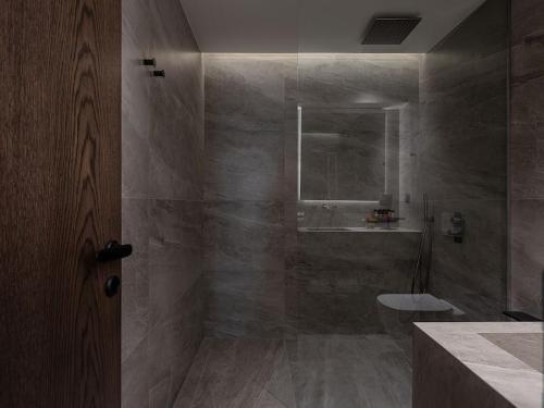 a bathroom with a shower with a toilet and a sink at ElKorin Jacuzzi Luxury Living in Chania