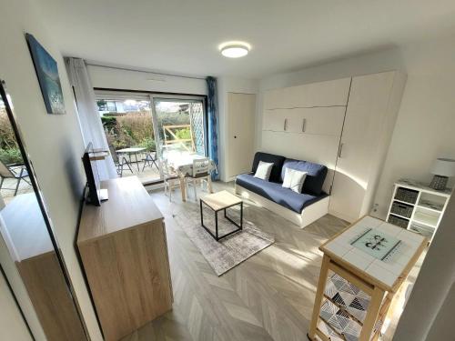 un salon avec un canapé et une table dans l'établissement STUDIO AVEC TERRASSE PLEIN SUD - RÉSIDENCE LE FENIL AVENUE DE VERDUN A CABOURG, à Cabourg