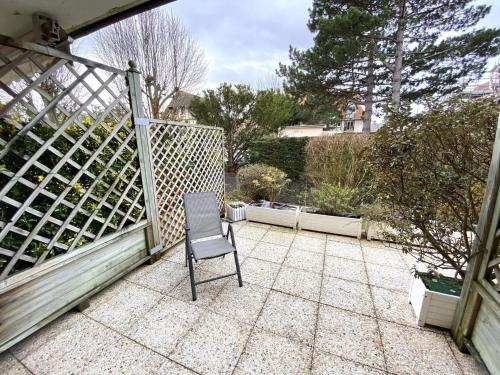 une chaise assise au-dessus du patio dans l'établissement STUDIO AVEC TERRASSE PLEIN SUD - RÉSIDENCE LE FENIL AVENUE DE VERDUN A CABOURG, à Cabourg