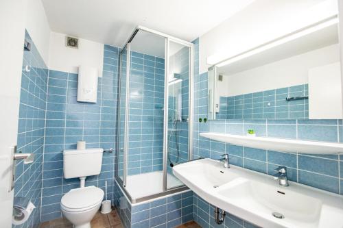 ヴェニングシュテットにあるAhrendt - Seesternの青いタイル張りのバスルーム(トイレ、シンク付)
