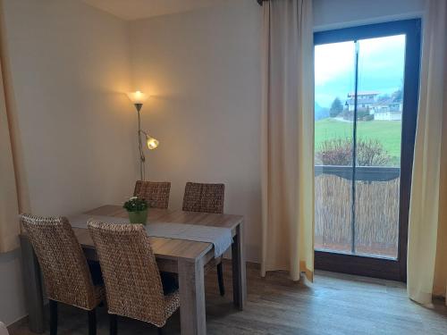 d'une salle à manger avec une table, des chaises et une fenêtre. dans l'établissement Appartements Kubisko, à Keutschach am See