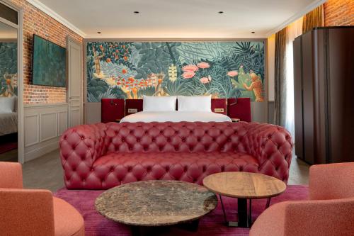 a living room with a red couch and a bed at Casa Faraona Luxury Residences in Madrid