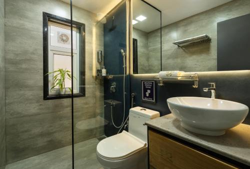a bathroom with a white sink and a toilet at SaffronStays Calvin - 3 Bedroom Pool Villa In Lonavala in Lonavala