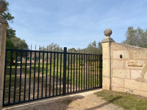 a black iron gate with a stone wall at Can Taco in Llucmajor