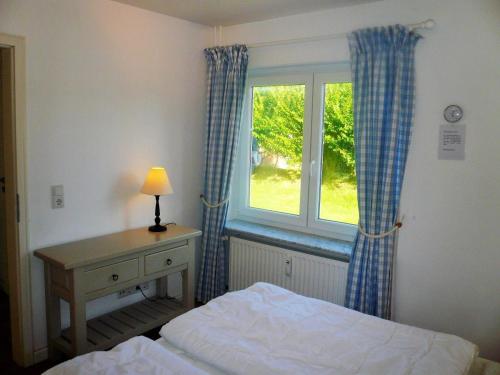 - une chambre avec un lit, une fenêtre et un bureau dans l'établissement Hüs Lörki 1, à Westerland