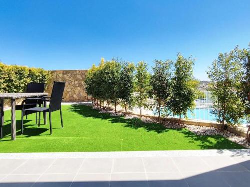 a yard with a table and chairs and a green lawn at Vistas Mar Villas D by Stay ici in Albufeira