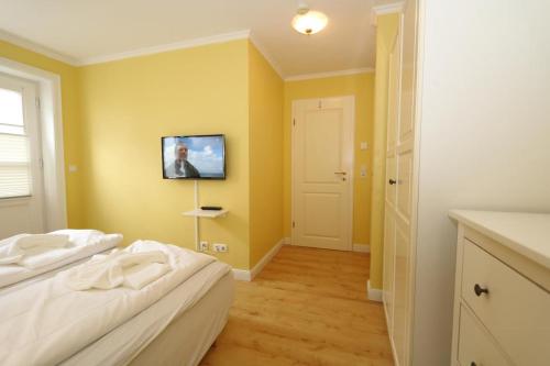 ヴェニングシュテットにあるThomas Mann /Landhaus Friedrichshainのベッドルーム1室(ベッド1台、壁掛けテレビ付)