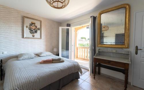 een slaapkamer met een bed, een spiegel en een raam bij La Rose Des Vents in Modène