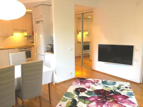a kitchen and dining room with a table and a television at Top Apartments Helsinki - Tilkka in Helsinki