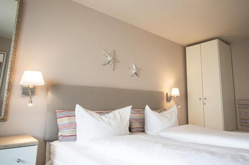 - une chambre avec 2 lits et des oreillers blancs dans l'établissement Spalthoff 18, à Westerland