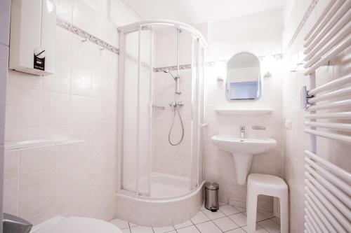 een witte badkamer met een douche en een wastafel bij App. Bagehorn 10 in Westerland