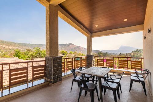 a patio with a table and chairs on a balcony at Hillside Resort Lonavala - Pawna - Mountain View in Lonavala