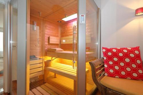 - un sauna avec un banc et un oreiller rouge dans l'établissement App. Hookipa EG/UG, à Westerland